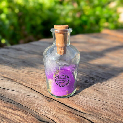 Bouteille lumineuse souvenir posée sur une table en bois au soleil, remplie de petites lumières et décorée d’un message symbolique — création destinée à honorer la mémoire d’un animal.