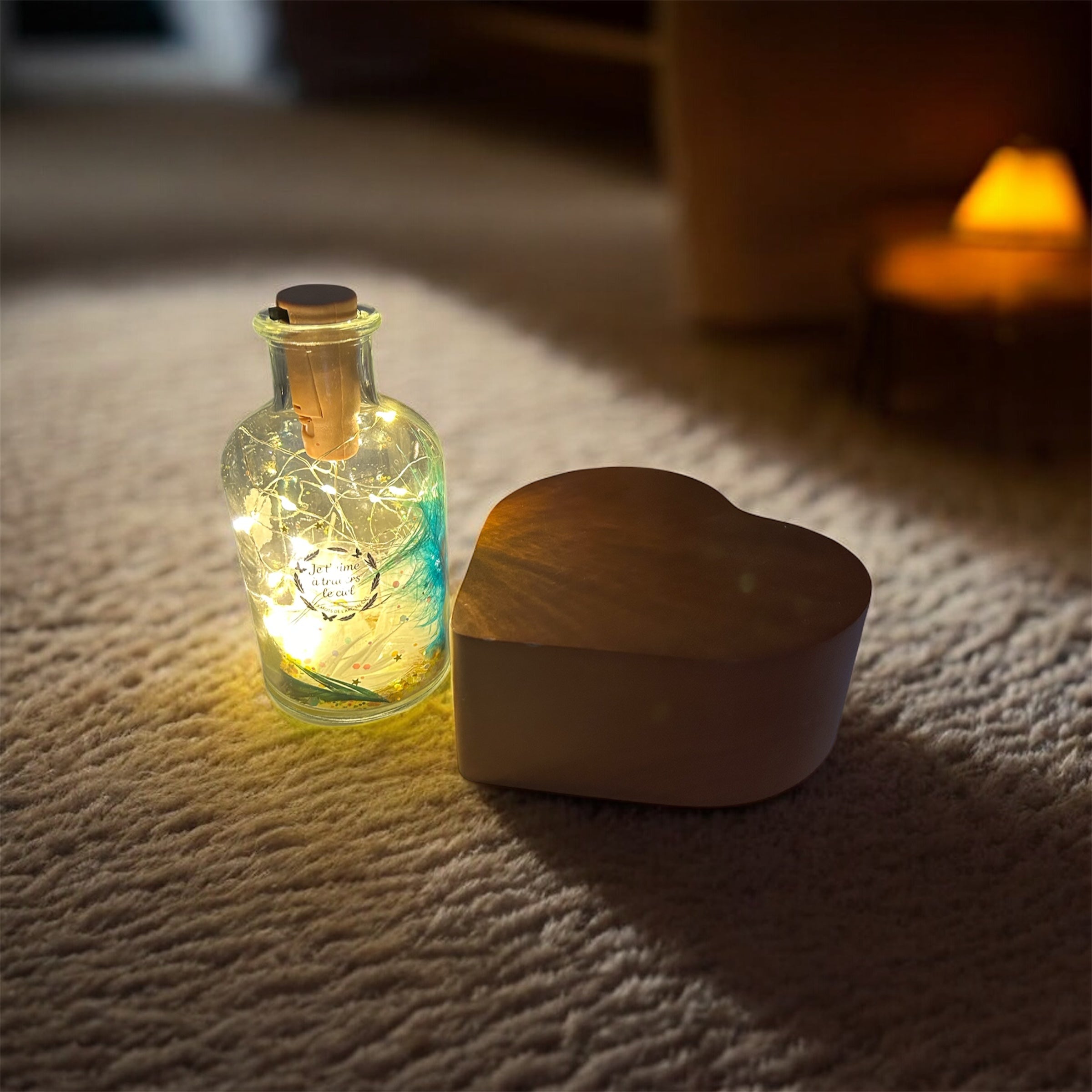 “Bouteille lumineuse souvenir éclairée d’une douce lueur, posée sur un tapis, à côté d’une urne en forme de cœur — création symbolique pour honorer la mémoire d’un animal.”